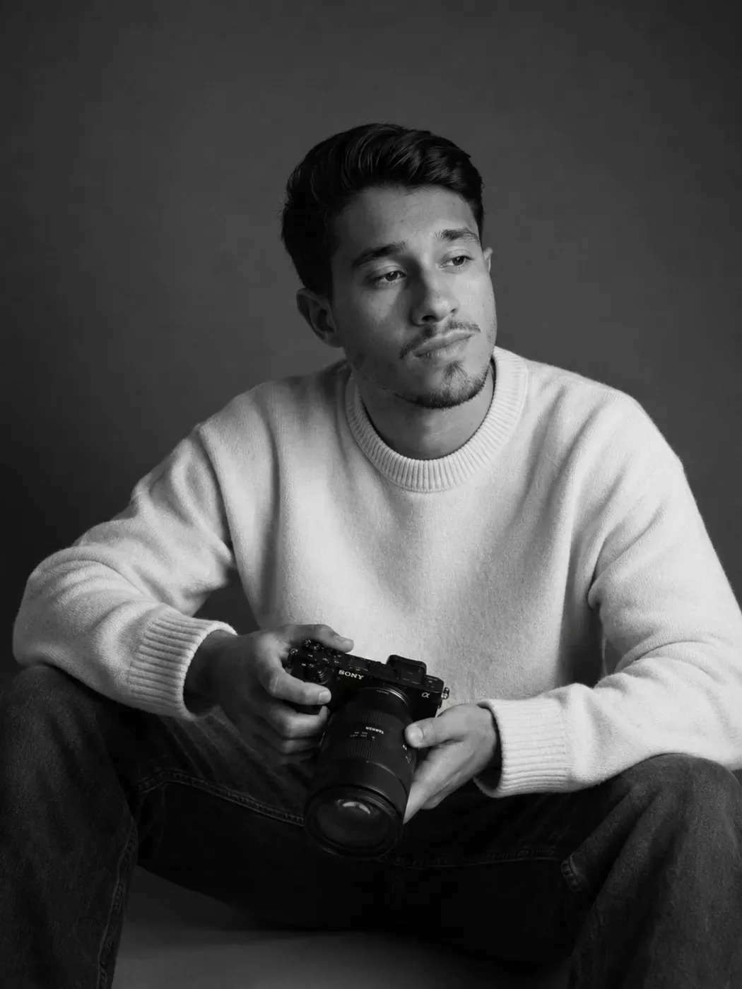 Retrato editorial em preto e branco com câmera profissional.